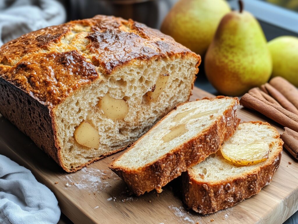 Freshly baked pear bread loaf with a slice cut to show its moist texture