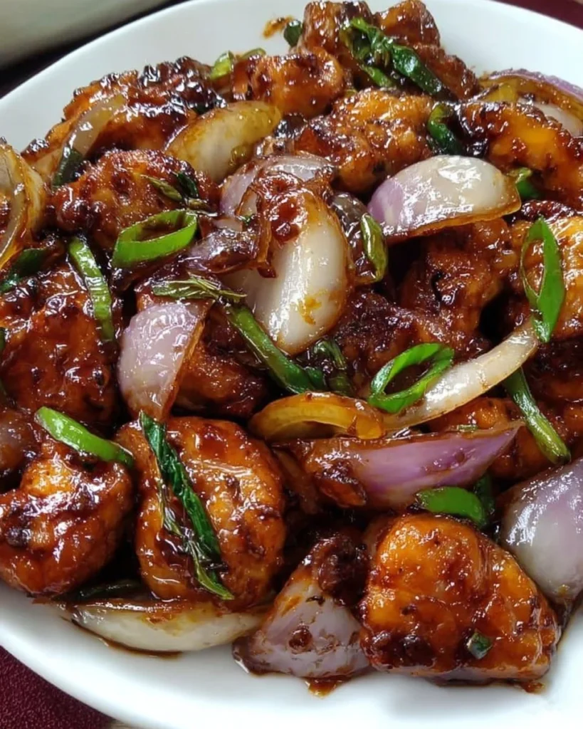 Stir-fried chicken with onions served on a plate with fresh herbs