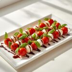 Vibrant Caprese skewers with cherry tomatoes, mozzarella, and basil drizzled with balsamic glaze, perfect no-cook holiday sides.