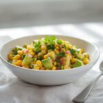 A creamy avocado corn salad in a white bowl, perfect for budget no-cook side dishes. Fresh and vibrant.