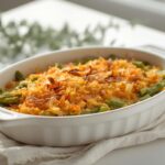 Elegant green bean casserole in a white baking dish, showing crispy topping and fresh beans, a delicious example of Christmas side dish shortcuts.