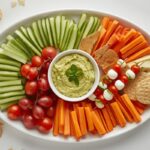 A vibrant platter of assorted no-cook holiday sides kid-friendly for festive gatherings, featuring veggies, fruit, and dip.